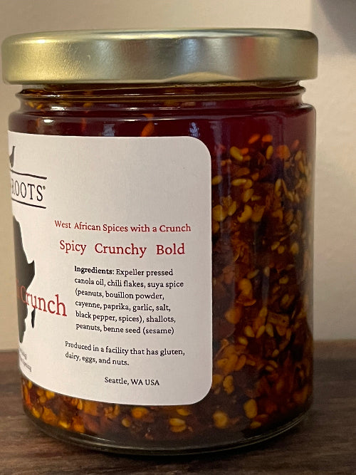 Jar of spicy crunchy spice mix with a label on a wooden surface
